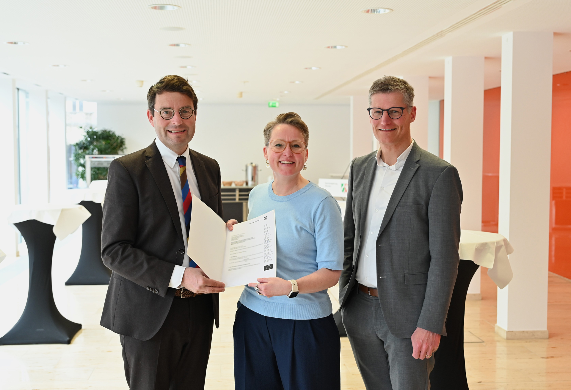 Andreas Bothe und Esther Dohmen halten eine Urkunde, Oberbürgermeister Tilmann Fuchs steht neben ihnen