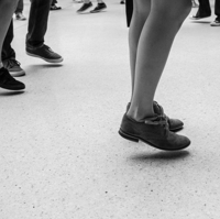 Schwarz-weiß Fotografie von tanzenden Beinen