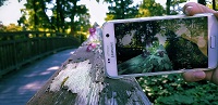 Foto für Projekt 'Smartphone-Fotografie'. Auf dem Foto ist ein Smartphone zu sehen, mit dem gerade ein Foto von der Natur gemacht wird.