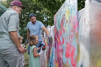 Abbildung von Menschen vor einer Graffiti-Wand