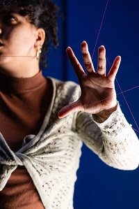 Foto zeigt eine Frau im Halbporträt; Gesicht und Körper sind am linken Bildrand angeschnitten.