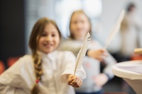 Abbildung eines Mädchens mit einer weißen Feder in der Hand