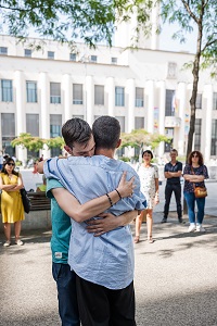 Foto von zwei Männern, die sich umarmen. Pedro Barateiro: My body, this paper, this fire, 2022, Performance IAC Villeurbanne (Courtesy the artist, Foto: Fanny Vandecandelaere)