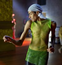 Tanzender Mann, der ein neongrünes Netz-Hemd trägt