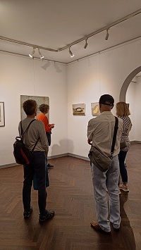 Vier Menschen in einer Galerie, die Bilder betrachten.