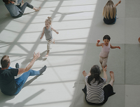 Abbildung von Kindern, die in die Arme ihrer Eltern laufen.