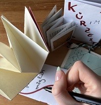 Eine Person gestaltet Mini-Magazine.