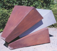 Drei aufeinander gestapelte dreieckige Prismen aus rostigem und silbernem MetallMetall