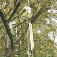 Installation mit vielen silberglänzenden Metallprofilen in einem Baum