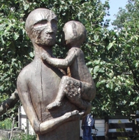 Schwarze Holzskulptur einer Frau mit Kindern