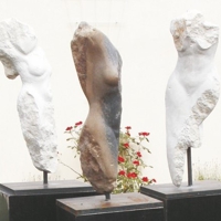 Drei Torsi weiblicher Figuren aus hellem Stein