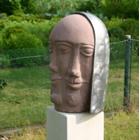 Kopf mit drei Gesichtern aus rötlichem Sandstein mit einer Haube aus Zinnguss