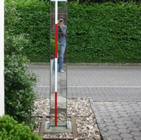 Installation aus schmalem Hochkant-Spiegel mit rot-weißer Vermessungsstange
