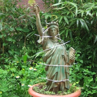 Nachbildung der Freiheitsstatue in einem Blumentopf mit Lichterkette