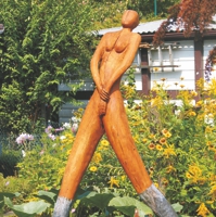 Übergroße Frauenskulptur aus Holz mit Metallstiefeln