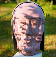 Kopf mit drei Gesichtern aus rotem Sandstein mit einer Metallhaube