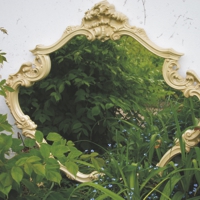 Vergoldeter Barock-Spiegel steht im Beet