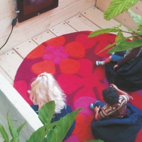 Modell mit drei Personen in einem Raum vor Fernseher