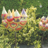 Farbige Phantasie-Früchte aus Keramik in einem Beet