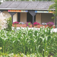 Farbiger Schriftzug an einer Gartenlaube