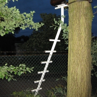 Weiße Metallleiter mit Sitz, an einen Baum gelehnt