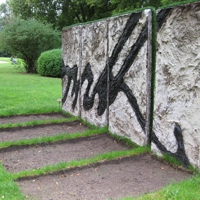 Drei hochkant stehende Betonplatten mit schwarzen Linien, die das Ende von Bismarcks Unterschrift darstellen