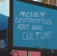 Foto eines blauen Containers mit dem Graffity: Money destroying Art and Culture