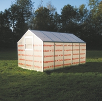 Gewächshaus mit roter Schrift auf einer Wiese