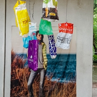Bewegliche Plastiktüten vor einem Werbeplakat