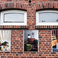 Verschiedene Fotomontagen an einer Ziegelwand