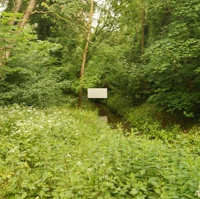 Weiße Tafel aufgeständert über einem Bach