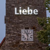 Schriftzug "Liebe" am Kirchturm der St. Josef-Kirche am Abend