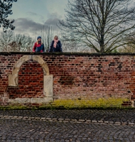 Zwei Frauen schauen über die Mauer des Pfründnerhauses