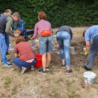 Menschen formen Zementgefäße an einem Erdhügel