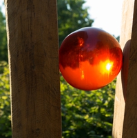 Zwei Holzbalken mit einer orangefarbenen Kugel dazwischen