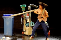 Die Schauspielerin Julia Hoffstaedter zieht einen langen dicken Schlauch aus einer blauen hohen Mülltonne.