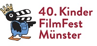 Logo 40. KinderFilmFest Münster Logo - Ein schwarzer Vogel in blauem Overall und einer Krone, dessen Schnabel wie eine Filmklappe in schwarz und weiß gestreift ist, zeigt auf den Text: 40. KinderFilmFest Münster.
