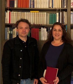 Das Team des Vorlese-Cafés Carsten Bender und Tanja Stermann stehen nebeneinander vor einem Bücherregal.