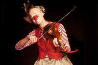 Ein Mann mit roter Clownsnase spielt Geige.
