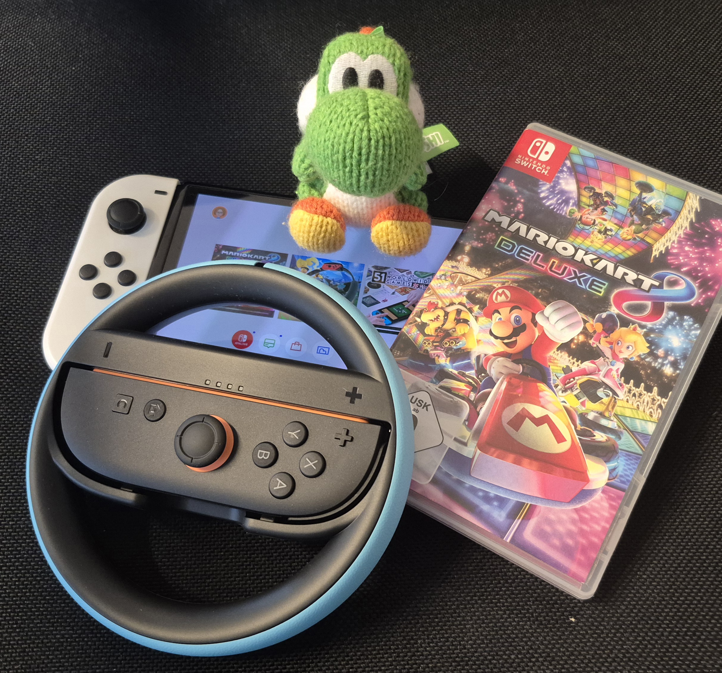 Eine Switch, ein Controller und ein Mario Kart-Game liegen bereit.