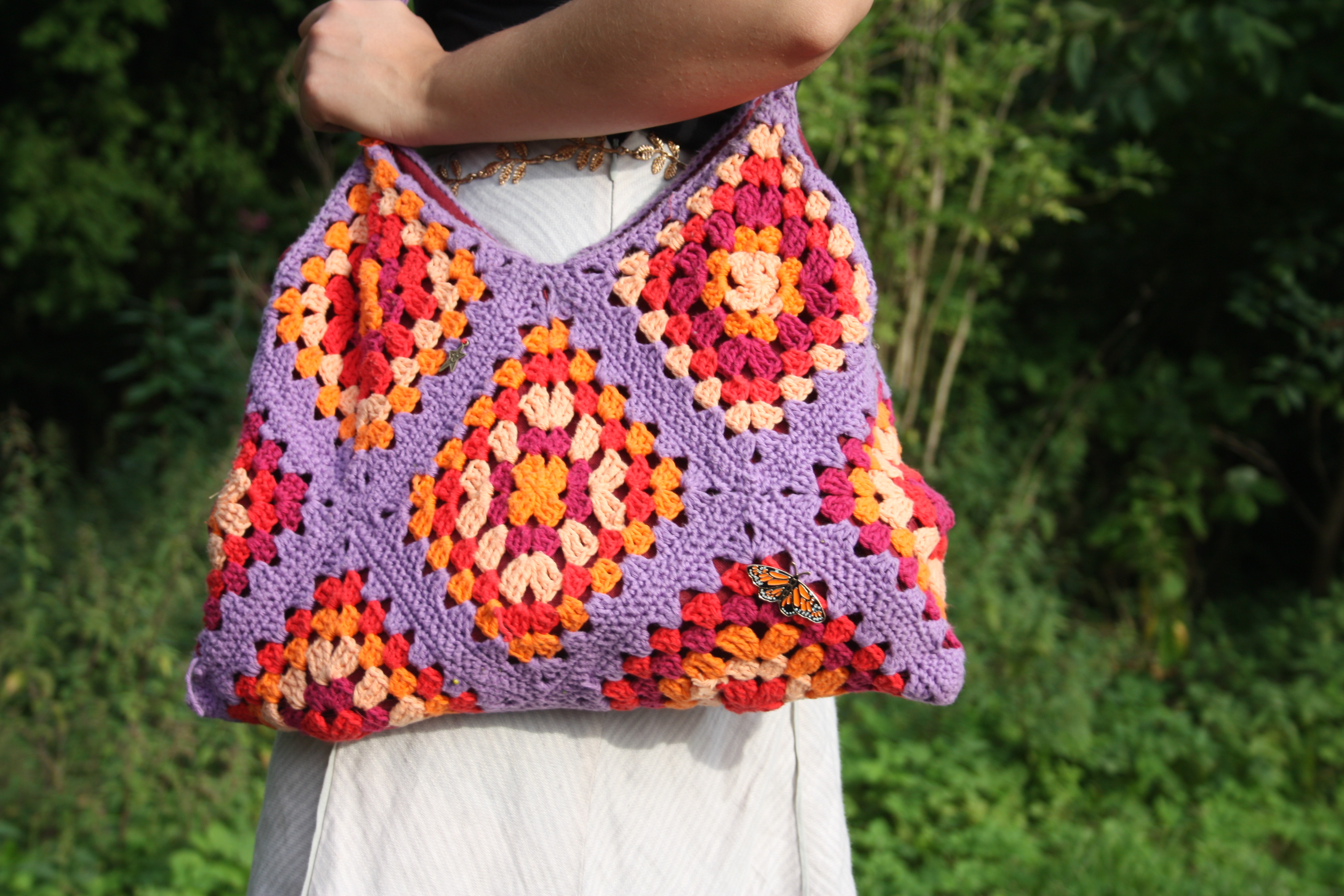 Eine Frau trägt eine gehäkelte Tasche.