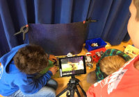 Trickfilm Szene im Filmstudio: Drei Kinder hinter der Kamera blicken auf den Bildschirm und drehen einen Trickfilm