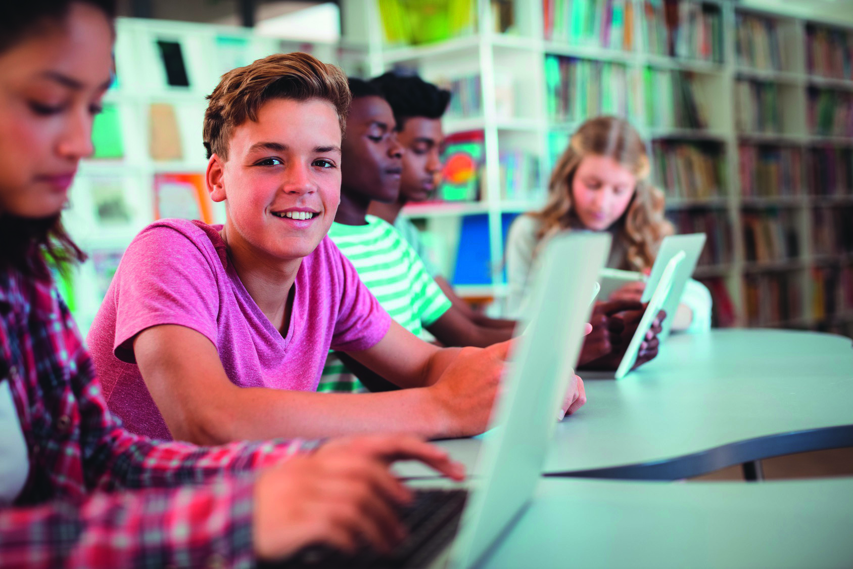 Kinder mit Notebooks in einer Bibliothek