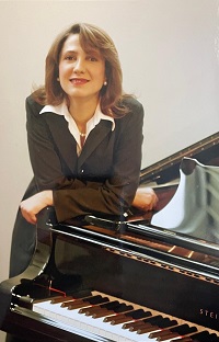 Anoosha Golestaneh stützt sich mit den Armen auf einem Klavier/Flügel ab.