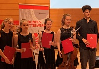 Vier Jugendliche mit ihren Instrumenten und den Urkunden mit der Auszeichnung als Preisträgerin und Preisträger.