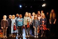 Gruppe junger Schülerinnen und Schüler auf einer Bühne