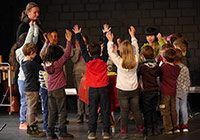 Gruppenfoto mit Kindern, die im Kreis stehen und singen