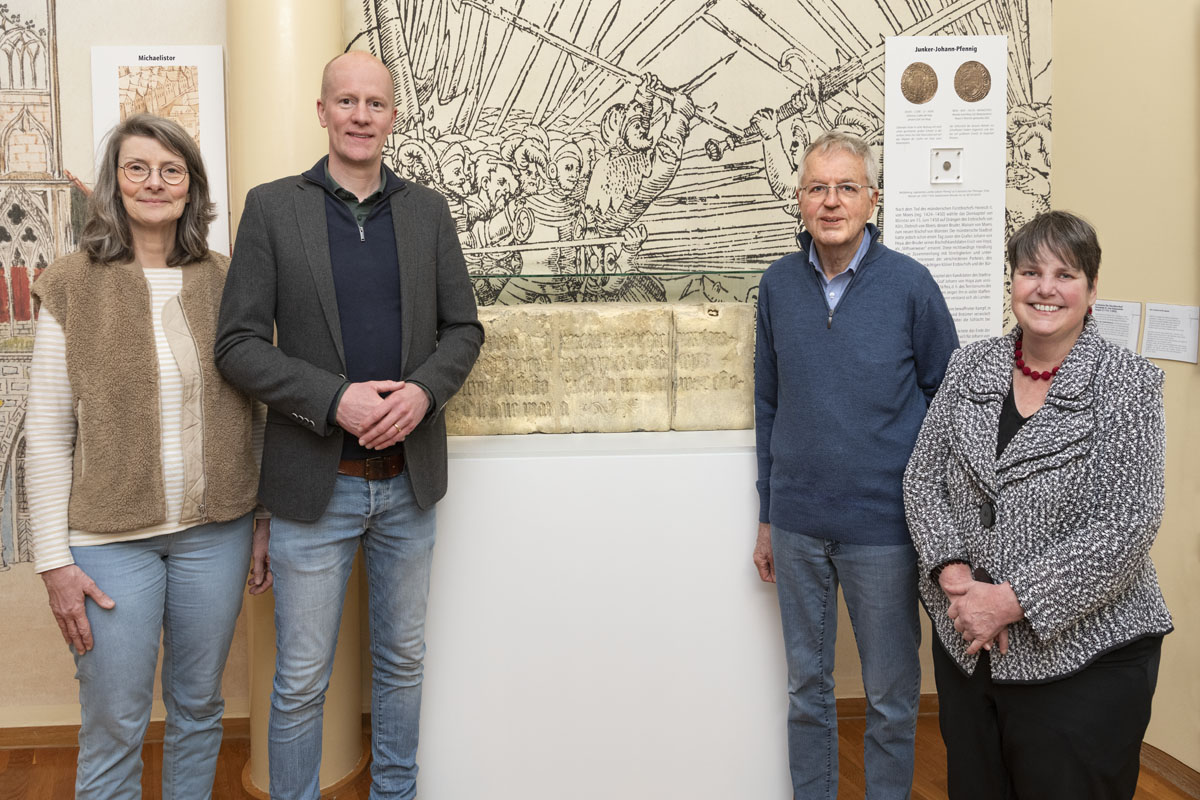 Vier Personen stehen neben dem Gedenkstein