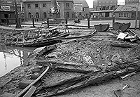 Der zerstörte Stadthafen in Münster am 2. Juli 1940. Im Vordergrund rechts ist ein Bombenkrater sowie die zerstörten Schienen neben der durch die Detonation angehobenen Uferbefestigung zu erkennen.