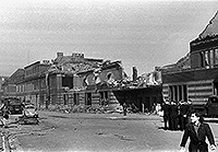 Das dachlose, zerstörte Bahnhofsempfangsgebäudes im September 1944. Auf der Straße vor dem Gebäude befinden sich mehrere Fahrzeuge und Personen.